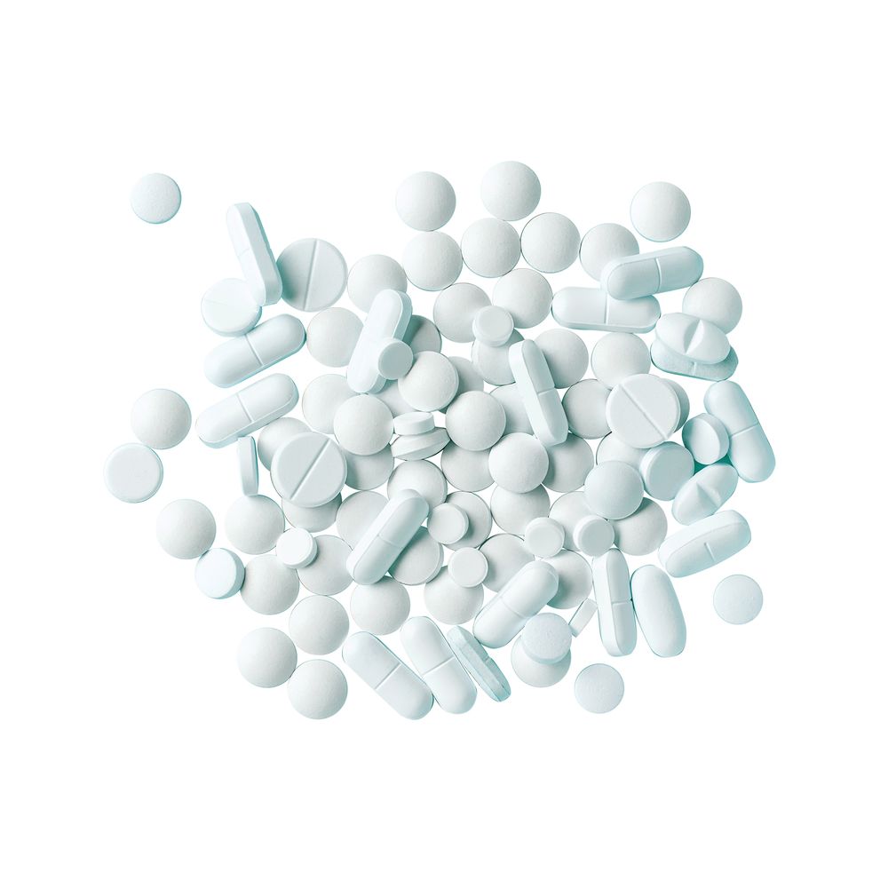 Group of white pills on a white background.