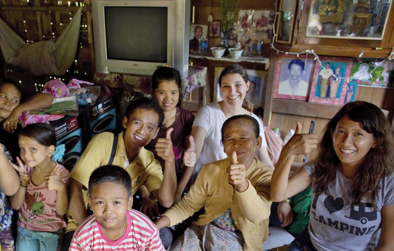 Margie Mason poses with Myint Naing and his family. 