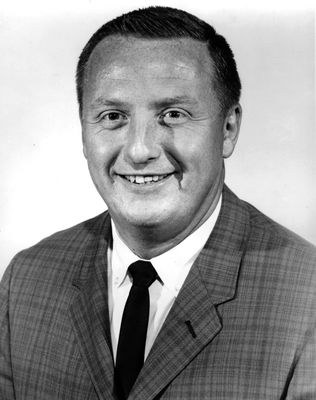 Black and White photo of former basketball coach Sonny Moran who is wearing a suit and tie. 