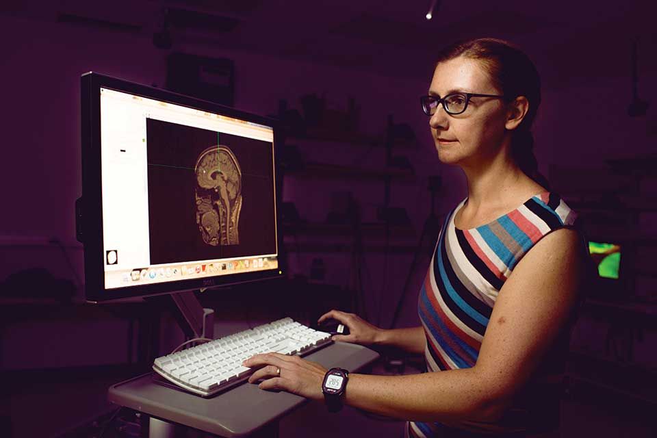 Valeriya Gritsenko looks at the image of a brain on a computer.