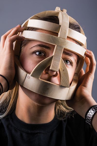 Nica Morrison wears a wooden cage on her head.