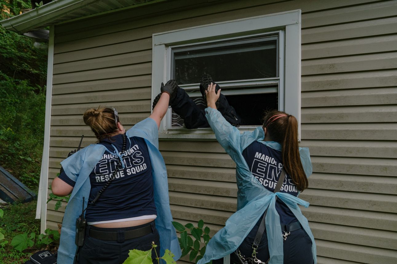 Marion County EMS medics push one of their coworkers into the window of a residence after discovering the front door was locked in Marion County, West Virginia. The patient was presumed to have COVID-19, requiring extra PPE on August 6th, 2020. 
