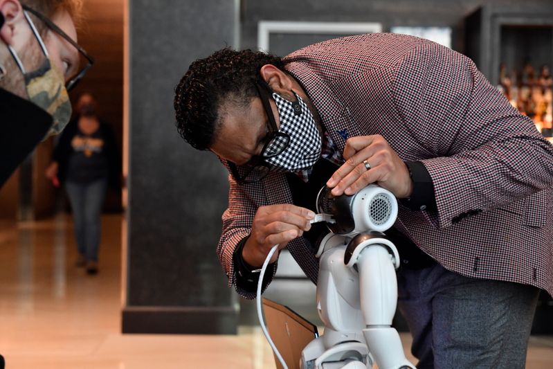 Ajay Aluri, director of the HIT Lab, tests a robot designed for use in the hotel industry. Brian Persinger Photo.jpeg