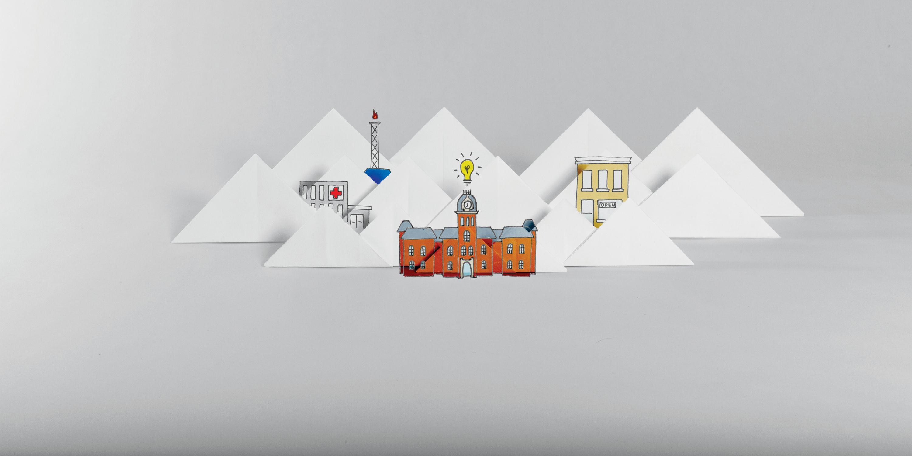 Origami depiction of Woodburn Hall, a gas well and a downtown among mountains