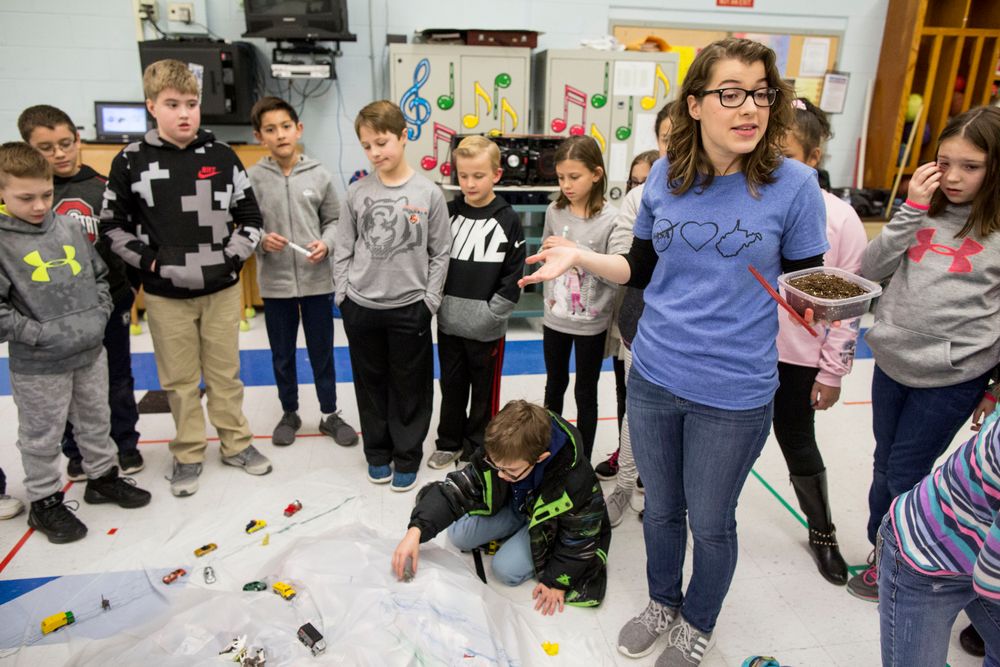 Madison Riffe directs children to make a model of a watershed.