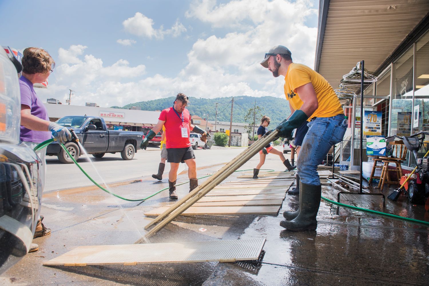 Volunteers help a store owner clean up after the flood.