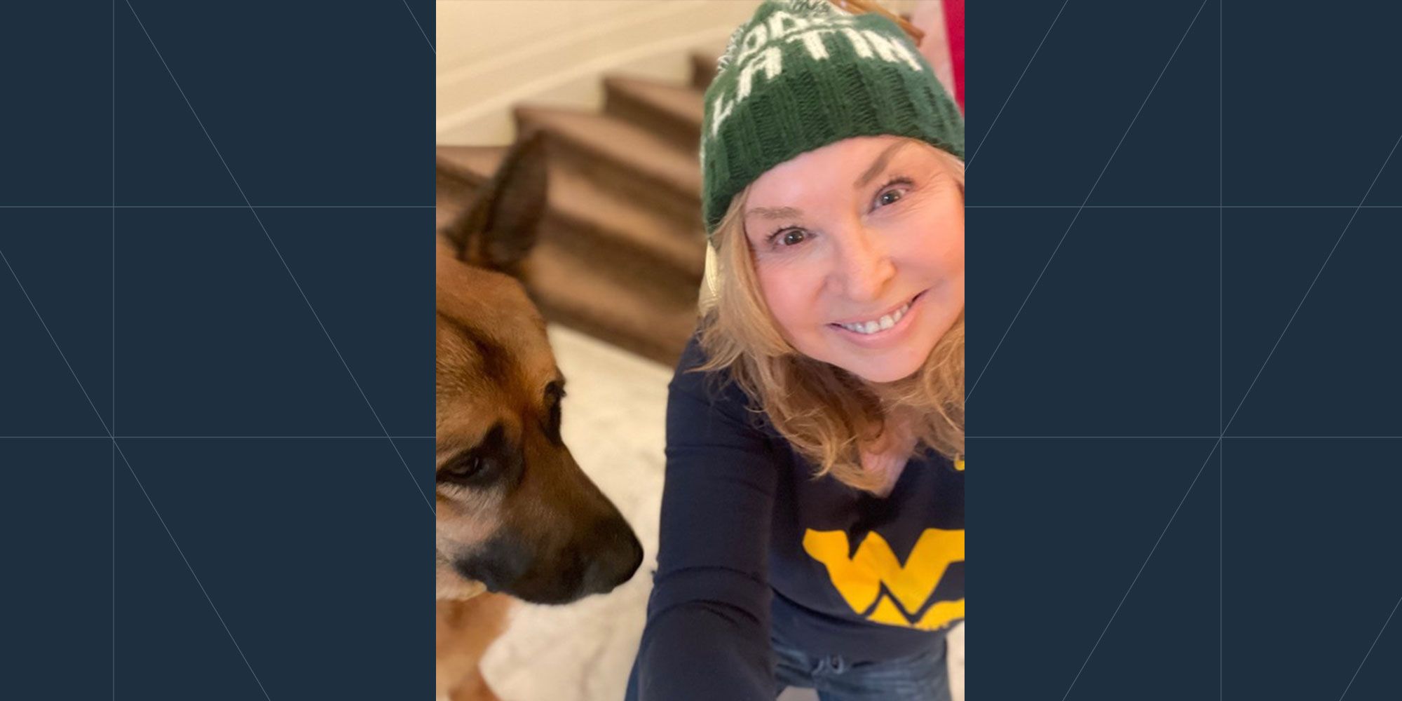 closeup of woman in toboggan, flying wv shirt, brown dog to her right