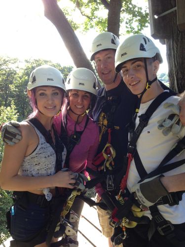 Image of Alexandra, Kim, TJ and Nolan Burch wearing helmets on a zipline platform.
