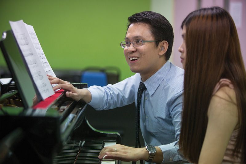 Yew Choong Cheong works with a student at the piano.