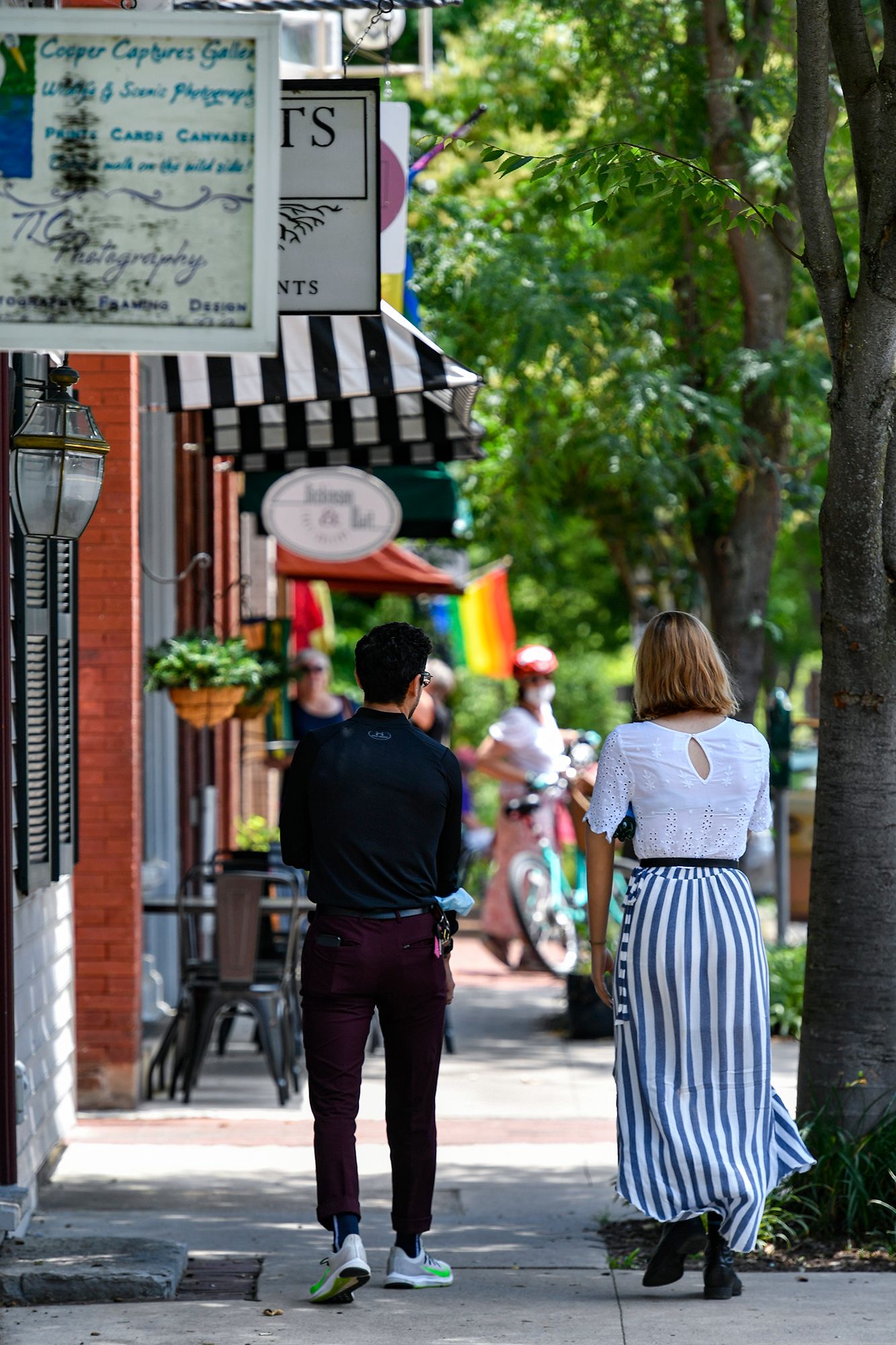 Two people walk down a sidewalk in Shepherdstown.