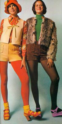 Two women wearing tights and short shorts, one with a furry jacket and the other in a vest and hat.