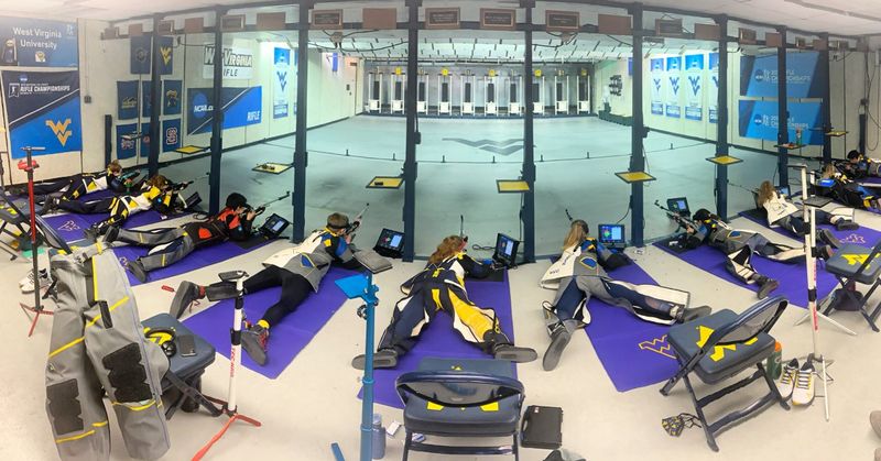 The rifle team laying on mats pointing rifles toward targets at their range.
