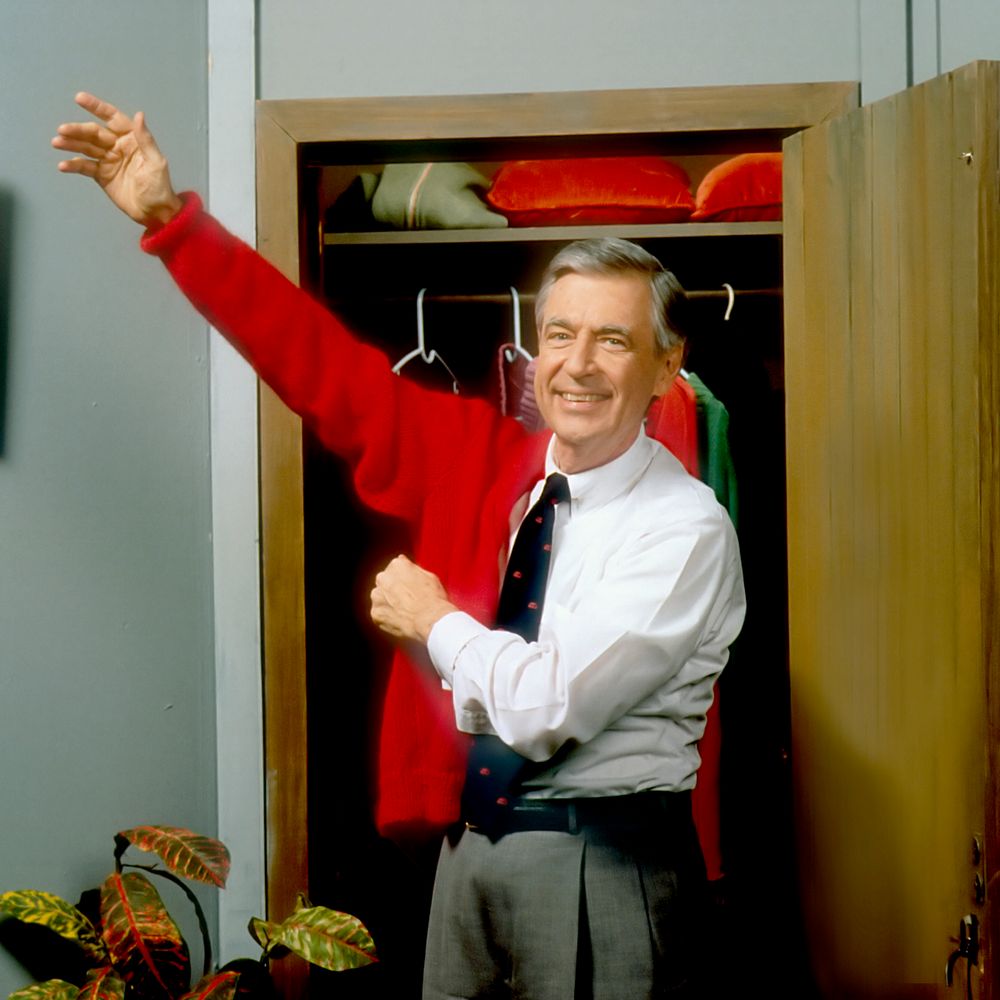 Mister Rogers putting on sweater photo