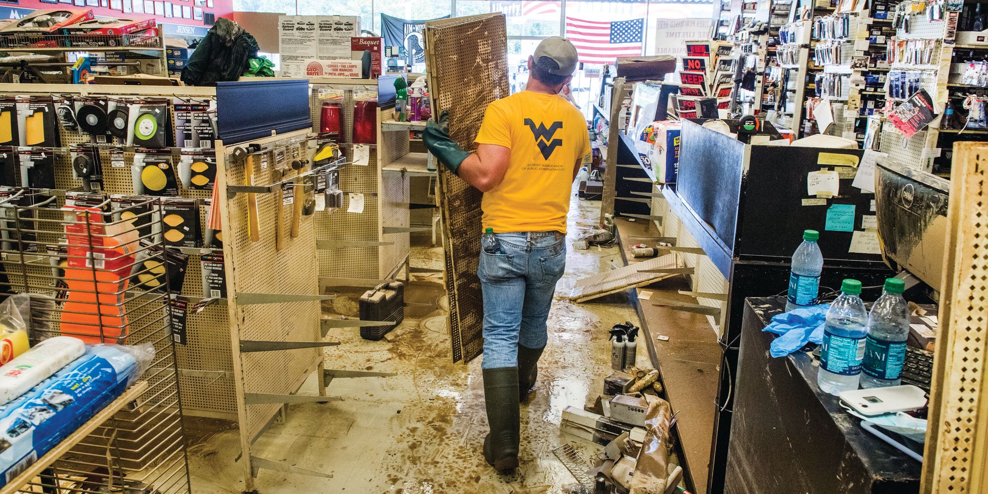 Student cleaning flooded store.