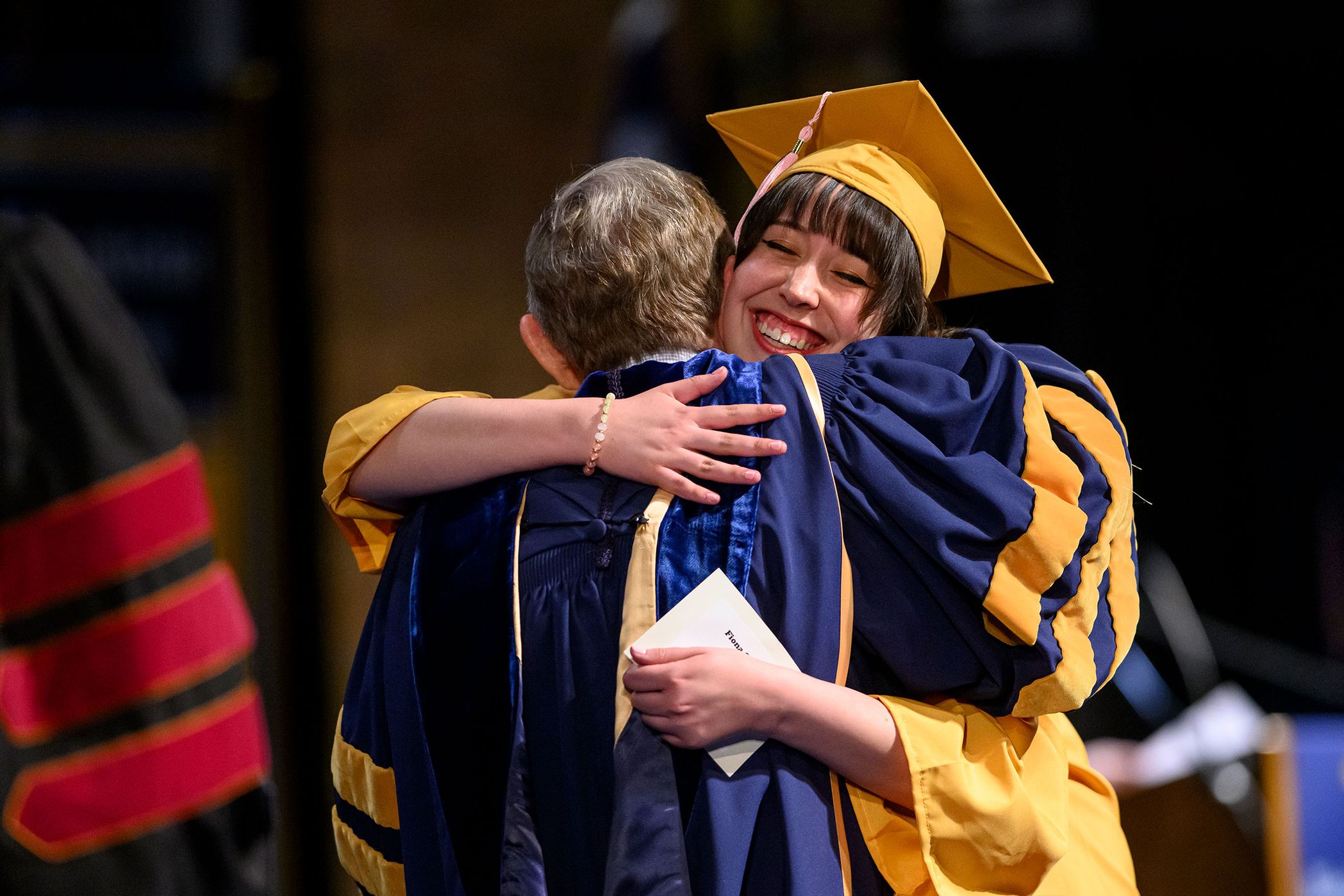 people hug during graduation ceremony
